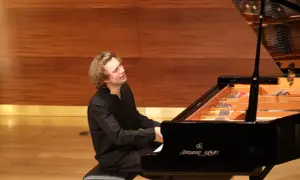 Ein junger Mann spielt mit Leidenschaft Klavier. Seine Hingabe lässt ihn wie den besten Pianisten der Welt wirken.
