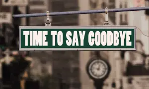 Ein Schild mit der Aufschrift "TIME TO SAY GOODBYE" hängt über einer Straße. Es ist Zeit für einen **Lied Abschied**.