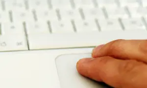 Finger auf einem weißen Laptop-Touchpad. Suche nach professionelle midifiles kostenlos für dein nächstes Musikprojekt.