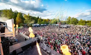 Große Menschenmenge feiert bei einem Konzert mit Flammenwerfern und Konfetti. Die "Malle Hits" bringen die Stimmung zum Kochen.