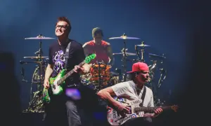 Blink 182 heute: Mark Hoppus spielt Bass, Travis Barker am Schlagzeug, Tom DeLonge mit Gitarre. Energiegeladener Auftritt!