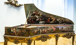 Ein prachtvolles Cembalo, verziert mit barocken Malereien, wie sie Johann Sebastian Bach liebte. Ein geflügelter Putto schwebt darüber.