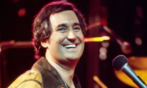 Lachender Mann mit Mikrofon, der vielleicht das bekannteste Lied der Welt singt.