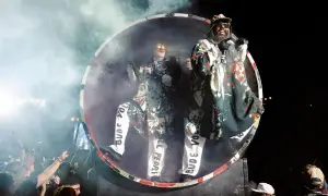Deichkind-Fans feiern im Hamsterrad, während die Band auf der Bühne performt.