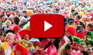 Bunte Kostüme und fröhliche Gesichter bei einem Karnevalsumzug. Hier gibt es die besten Karneval Lieder zum Mitsingen!