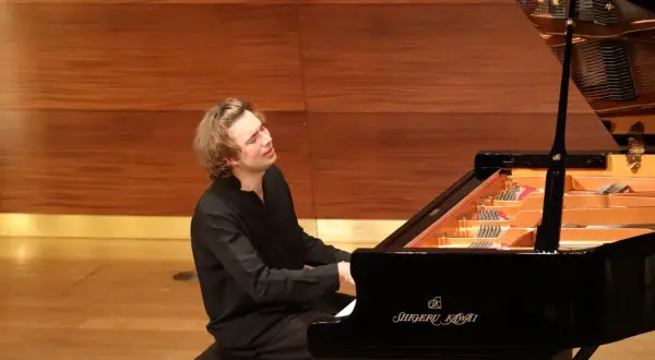 Ein junger Mann spielt mit Leidenschaft Klavier. Seine Hingabe lässt ihn wie den besten Pianisten der Welt wirken.