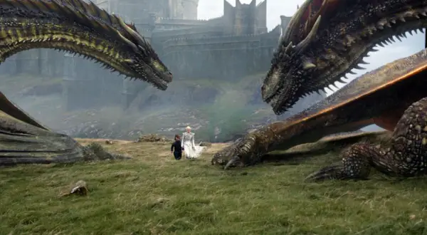 Zwei Drachen blicken sich gegenüber, während Daenerys und Tyrion im Gras stehen. Die epische **Titelmusik Game of Thrones** beginnt.
