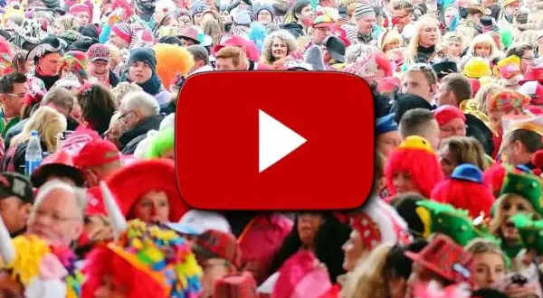 Bunte Kostüme und fröhliche Gesichter bei einem Karnevalsumzug. Hier gibt es die besten Karneval Lieder zum Mitsingen!