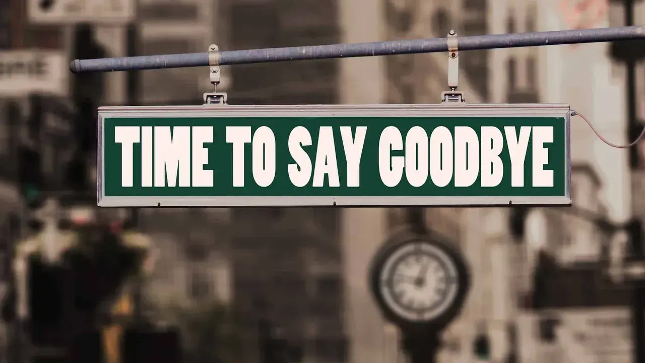 Ein Schild mit der Aufschrift "TIME TO SAY GOODBYE" hängt über einer Straße. Es ist Zeit für einen **Lied Abschied**.