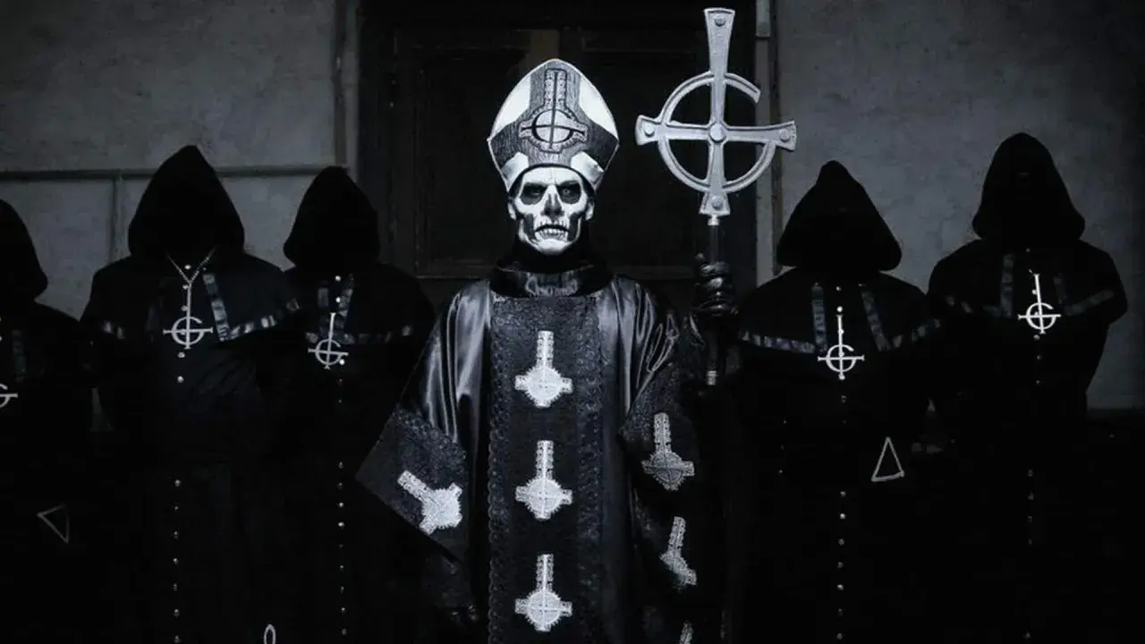 Geister-Frontmann mit Totenkopf-Make-up und Kapuzengewänder, die an beliebte Metal-Bands erinnern.