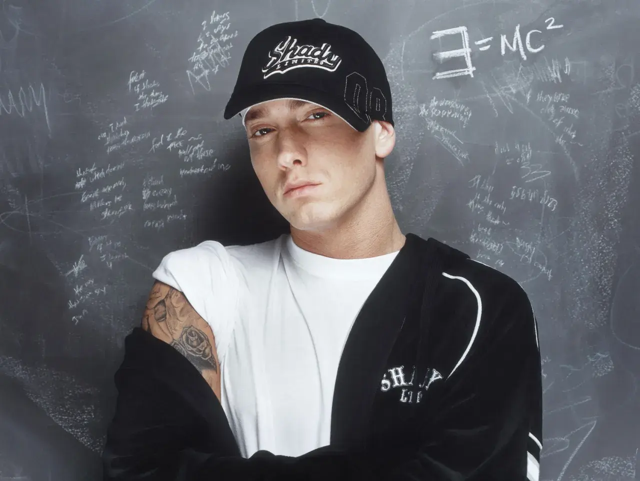 Eminem, der erfolgreichste Rapper, trägt eine "Shady"-Kappe vor einer Tafel mit Formeln und Texten.