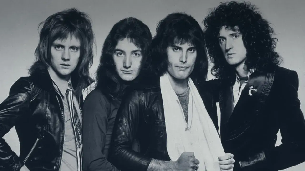 Die Mitglieder von Queen posieren für ein Schwarz-Weiß-Foto. Von links nach rechts: Roger Taylor, John Deacon, Freddie Mercury und Brian May.