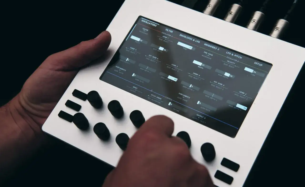Ein Nektar Pacer Synthesizer mit vielen Knöpfen und einem Touchscreen, auf dem verschiedene Parameter wie Oszillatoren und Filter angezeigt werden.
