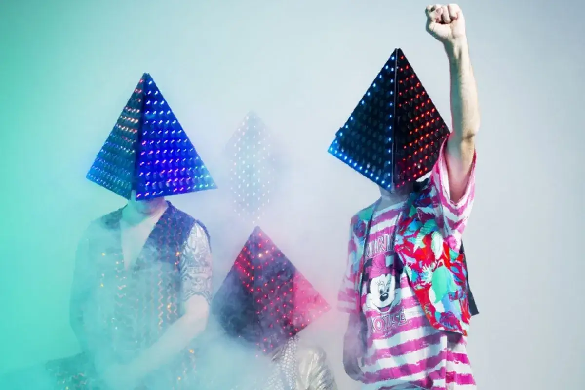 Deichkind illegale Fans mit leuchtenden Pyramiden-Masken und bunter Kleidung.
