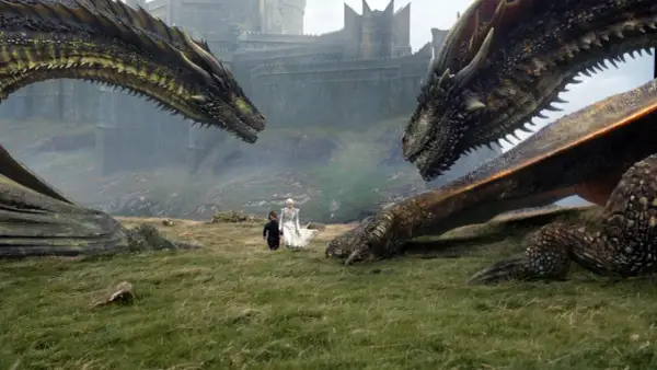 Zwei Drachen blicken sich gegenüber, während Daenerys und Tyrion im Gras stehen. Die epische **Titelmusik Game of Thrones** beginnt.