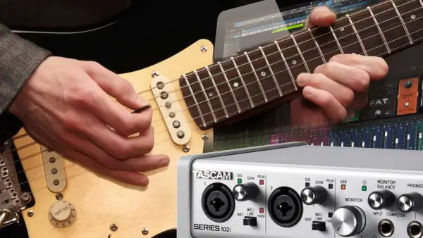 Gitarre aufnehmen PC: Hände spielen Gitarre, daneben ein Audio-Interface und eine DAW-Oberfläche.