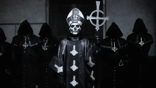 Geister-Frontmann mit Totenkopf-Make-up und Kapuzengewänder, die an beliebte Metal-Bands erinnern.