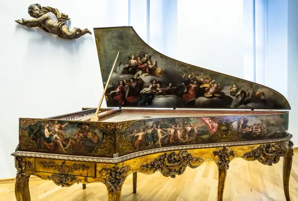 Ein prachtvolles Cembalo, verziert mit barocken Malereien, wie sie Johann Sebastian Bach liebte. Ein geflügelter Putto schwebt darüber.