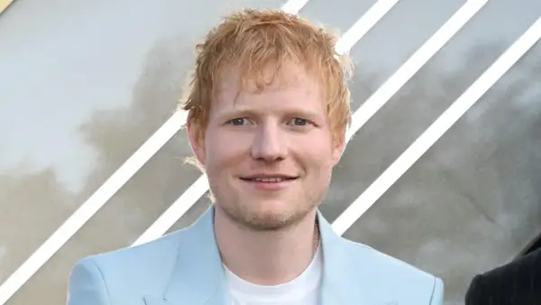 Ed Sheeran, der aus Halifax, England, stammt, lächelt in einem hellblauen Anzug.