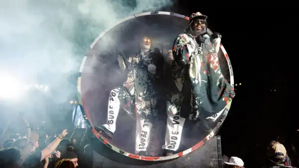 Deichkind-Fans feiern im Hamsterrad, während die Band auf der Bühne performt.