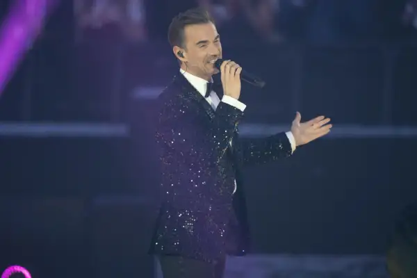 Ein Mann im glitzernden Sakko singt ins Mikrofon, ein typischer Auftritt der schlagerstars.
